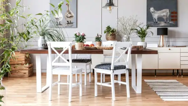 Comedor con mesa de madera oscura y sillas blancas, un ejemplo perfecto de cómo combinar muebles blancos y madera oscura para un estilo acogedor.